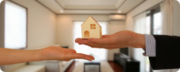 家の模型を手渡す様子