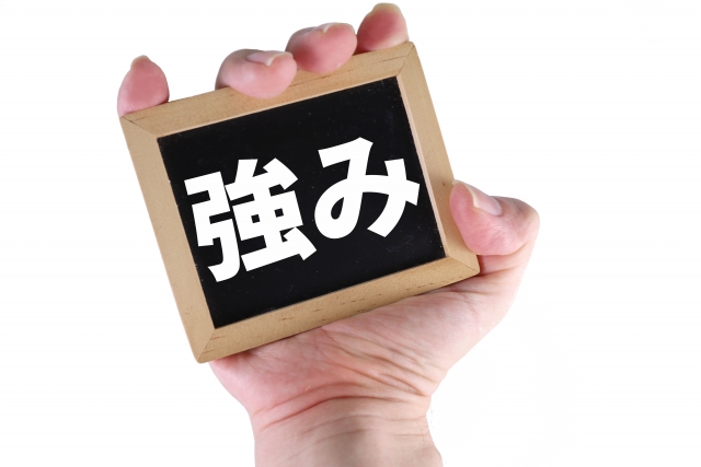 「強み」と書かれたボードを持つ手