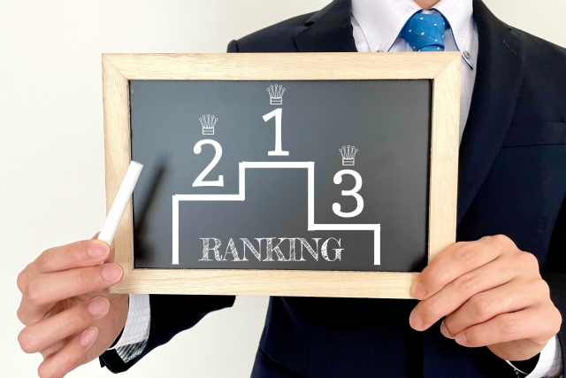 「RANKING」と書かれた順位ボードを持つ男性のイメージ