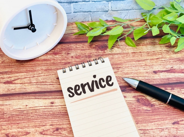 「service」と書かれたメモとペン。サービス内容を示すイメージ。