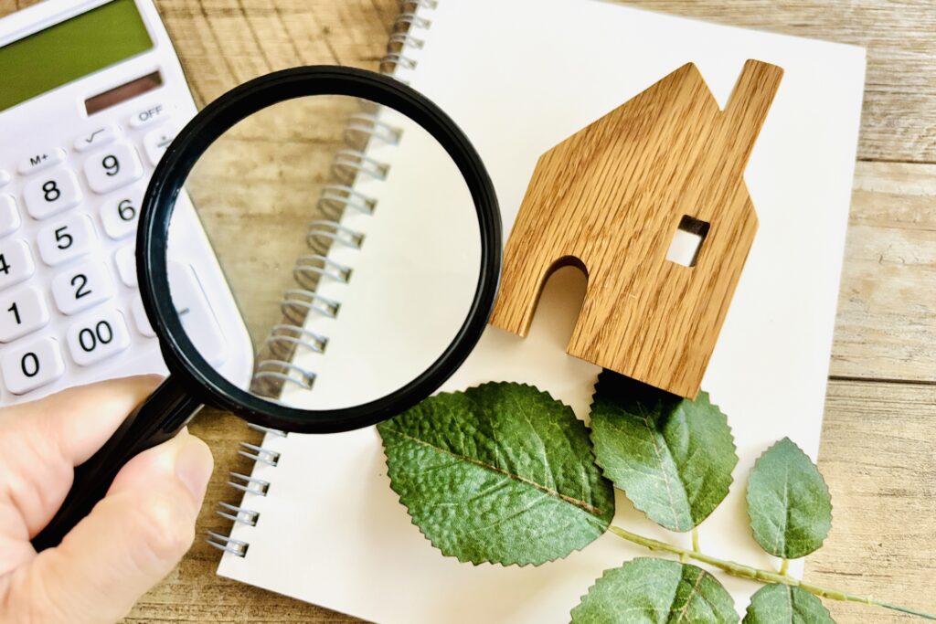 虫眼鏡と家の模型と観葉植物