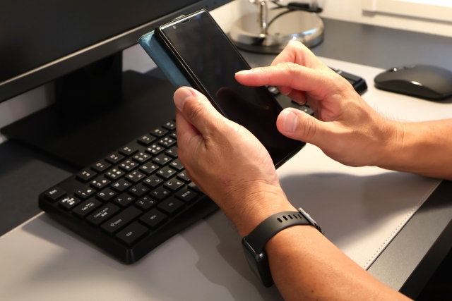 スマートフォンを操作する手元