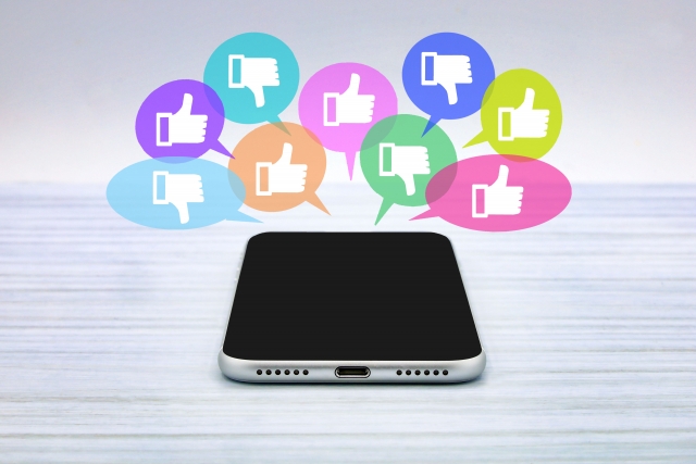 いいねマークと悪いマークのふきだしが出てるスマホ