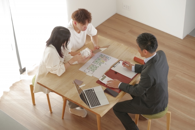 住宅模型と図面を使って不動産相談を行う様子