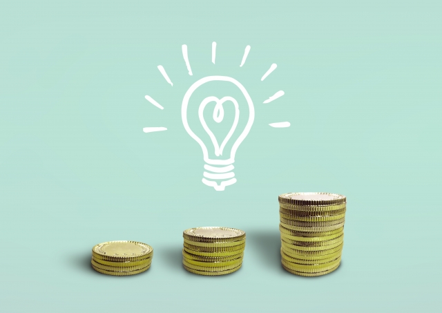積み重なるコインと電球のイラスト。