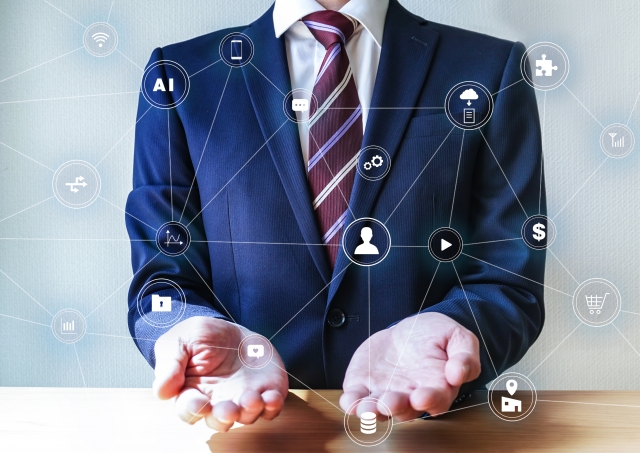 両手を差し出すスーツ姿の男性とネットワークアイコン