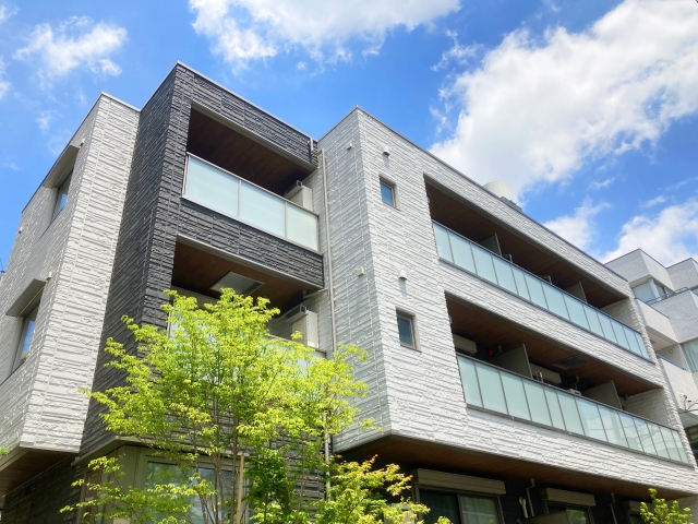青空の下に建つモダンなマンション外観