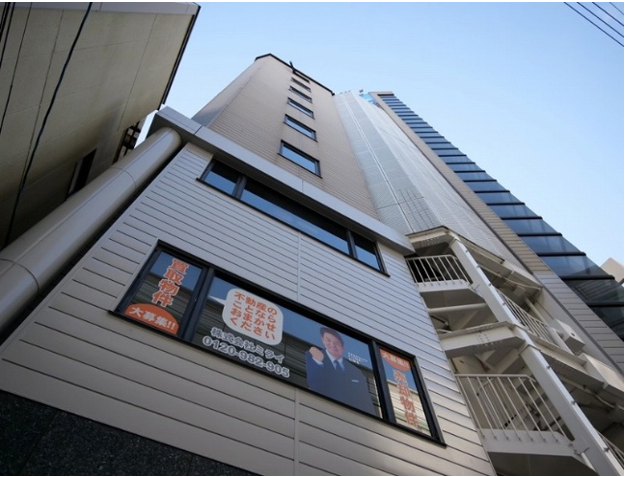 売却本舗 株式会社ミライのビル外観と不動産店舗の看板。